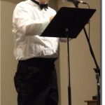 Henri Pensis narrates during a concert